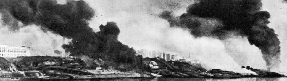 На фотографии через дым виден горящий Сталинград. Скорее всего фото сделано с противоположного берега Волги. Именно такую картину видели солдаты прежде чем отправиться через воду в огонь.